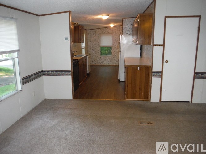A living room with a kitchen area in the background.