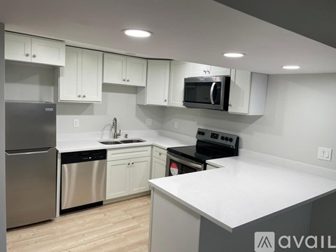 A modern kitchen with white cabinets and stainless steel appliances.