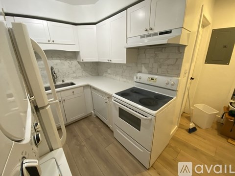 A modern kitchen with white appliances and cabinets.