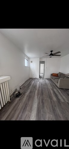 A room with wooden flooring and a ceiling fan.