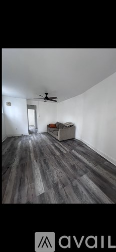 A room with wooden flooring and a ceiling fan.
