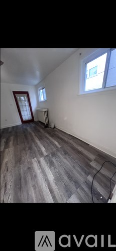 A room with wooden flooring and a window.