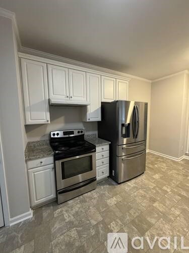 A kitchen with white cabinets and a black stove top oven.