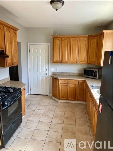 A kitchen with wooden cabinets and black appliances.