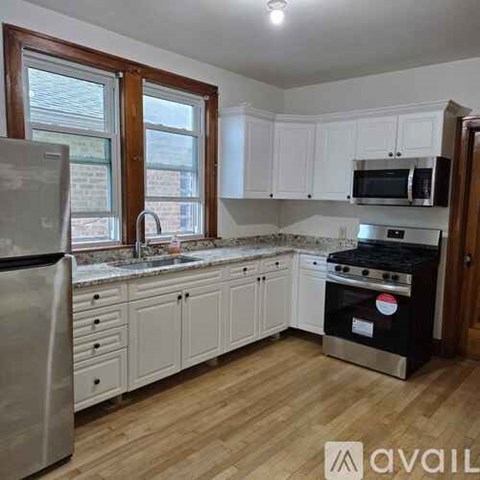 A kitchen with white cabinets and a black stove top oven.