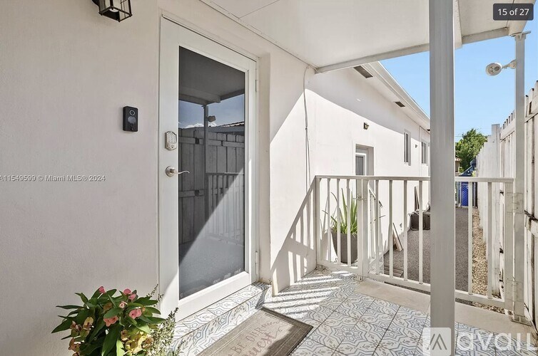 A balcony with a white railing and a glass door.