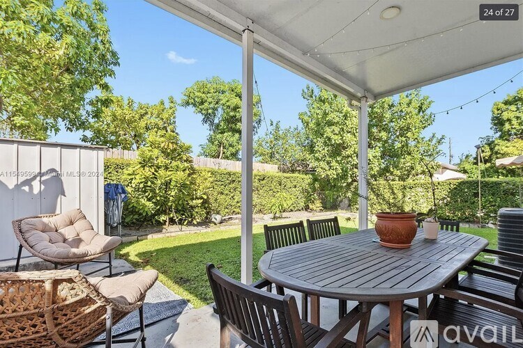 A patio with a table and chairs under a white canopy.