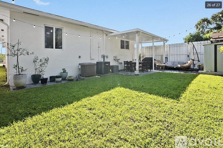 A white house with a green lawn in front.
