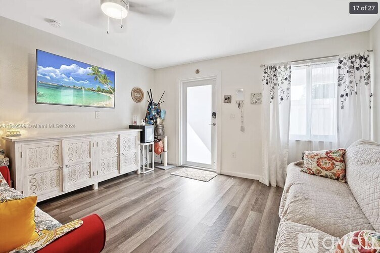 A living room with a television, a couch, and a chair.