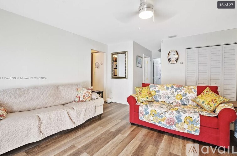 A living room with a red couch and a white sofa.