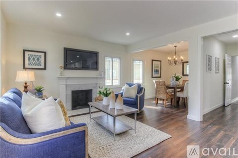 A living room with a blue couch and a fireplace.