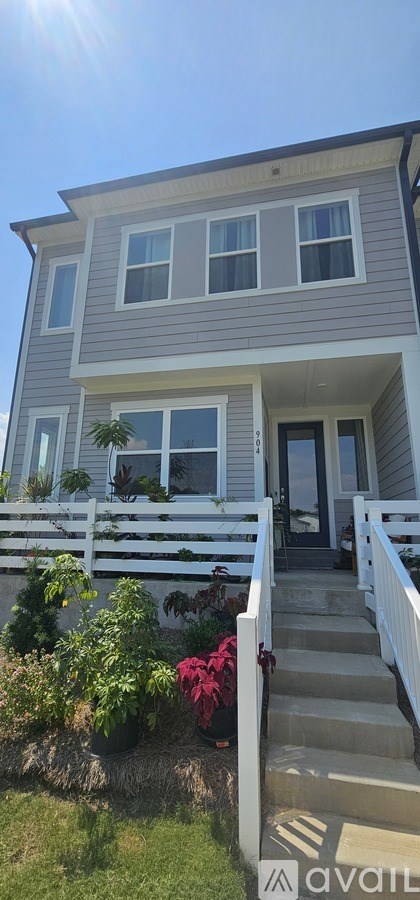 A house with a grey exterior and a white porch.