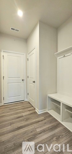 A shower with a glass door and a tiled wall.