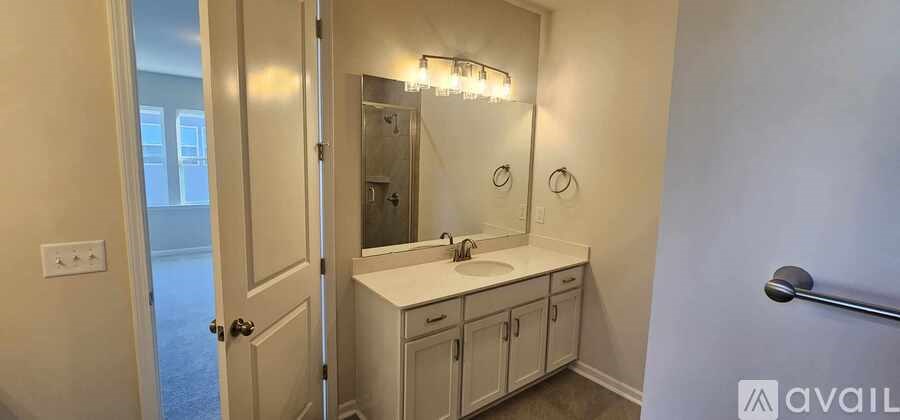 A bathroom with a sink, mirror, and cabinets.