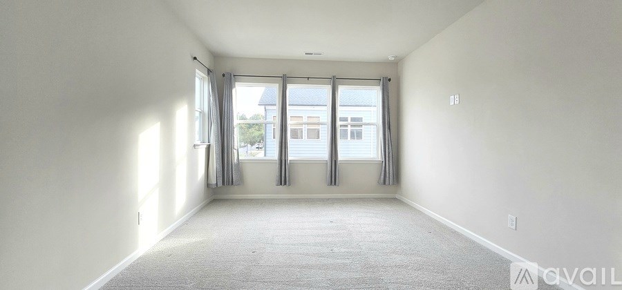 A room with three windows and carpeted floor.
