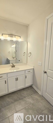 A bathroom with a sink, mirror, and cabinets.