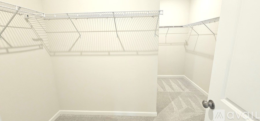 A white door is open to a hallway with a carpeted floor.