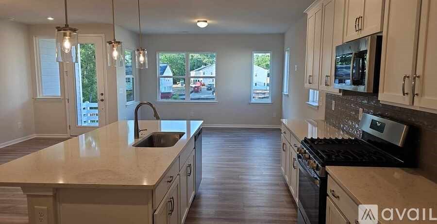 A kitchen with wooden floors and a large island with a sink.