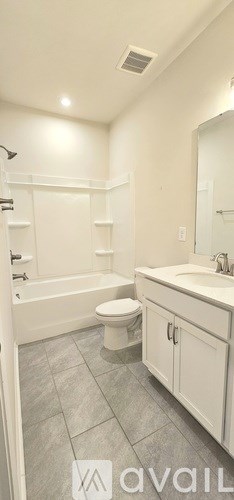 A bathroom with a toilet, sink, and a bathtub.
