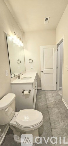 A bathroom with a toilet, sink, and mirror.