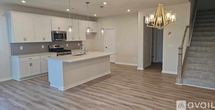 A spacious kitchen with a stove top oven and microwave above the island.