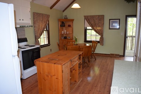 A kitchen with a wooden table and chairs.