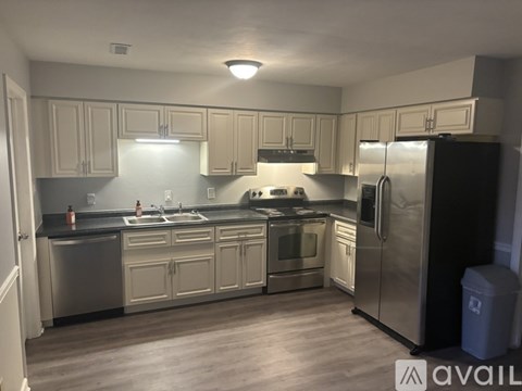 A kitchen with a black fridge and stainless steel appliances.