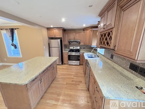 A kitchen with wooden cabinets and granite countertops is available.