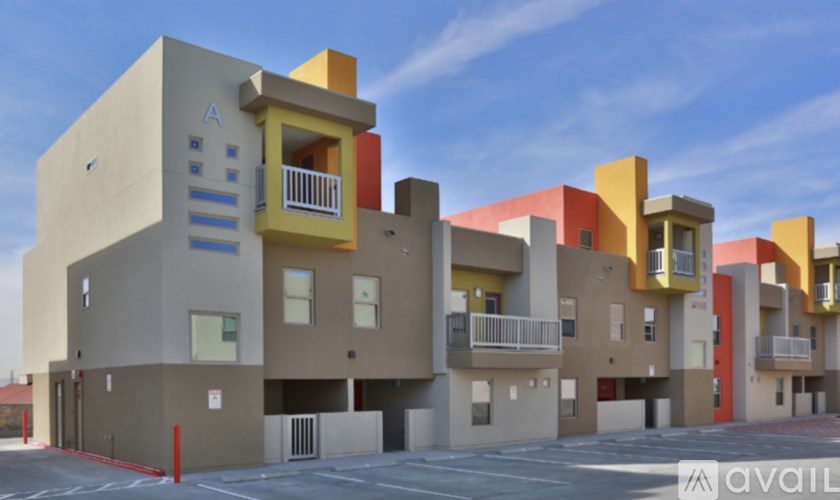 A modern apartment building with multiple balconies and a clear blue sky.