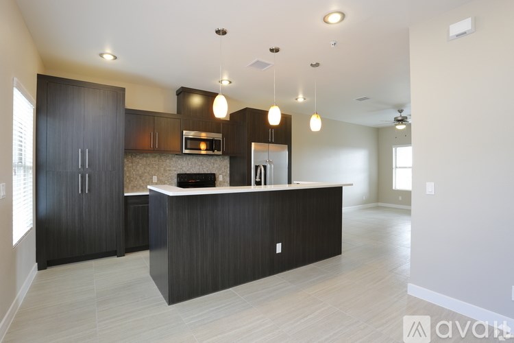 A modern kitchen with dark wood cabinets and a white countertop.