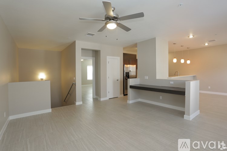 A spacious room with a ceiling fan and lighting fixtures.