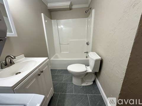 A bathroom with a toilet, sink, and bathtub.