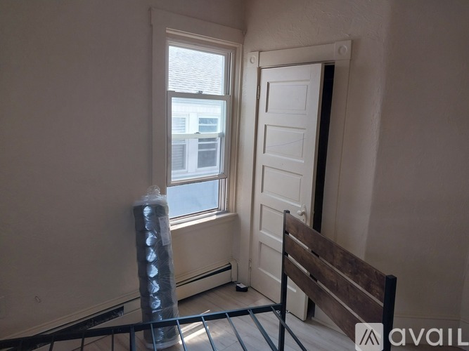 A room with a window, a door, and a bench.