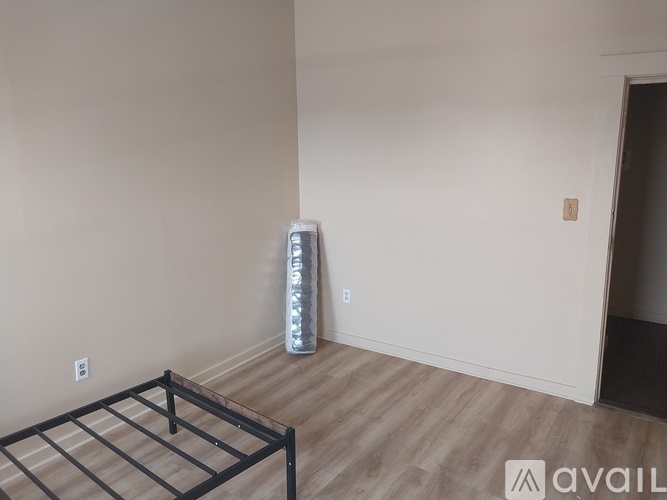 A room with a wooden floor and a mattress on the floor.