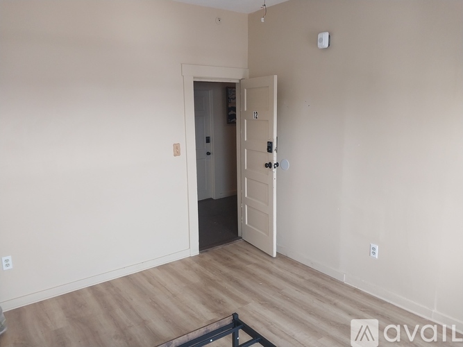 A room with a door and a wall-mounted smoke detector.