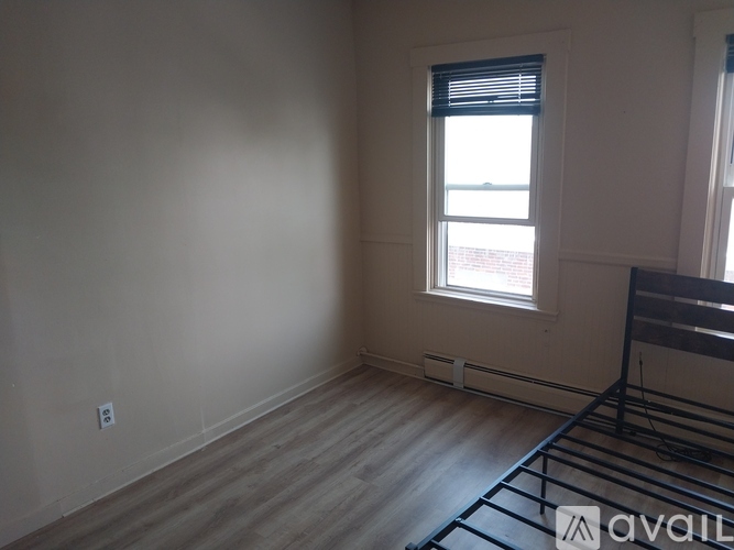 A room with a window and a wooden floor.