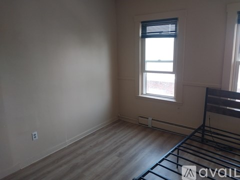 A room with a window and a wooden floor.