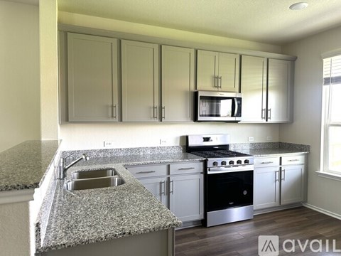 A kitchen with granite countertops and stainless steel appliances.