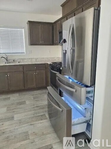 A modern kitchen with a stainless steel refrigerator and wooden cabinets.