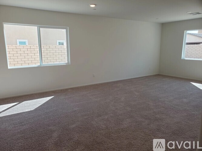 A room with a carpeted floor and two windows.