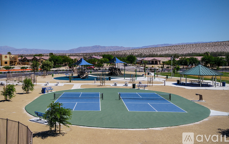 A tennis court surrounded by a fence and trees.