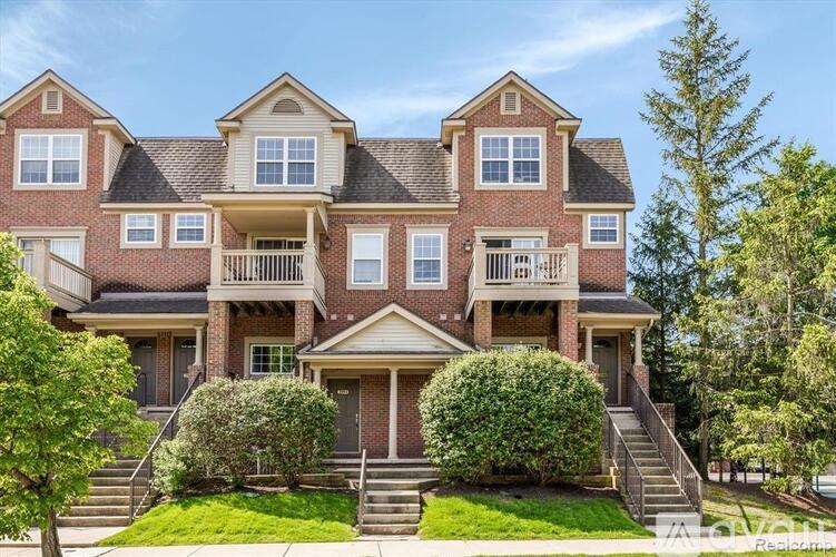 A large, multi-level house with a balcony on the second floor.