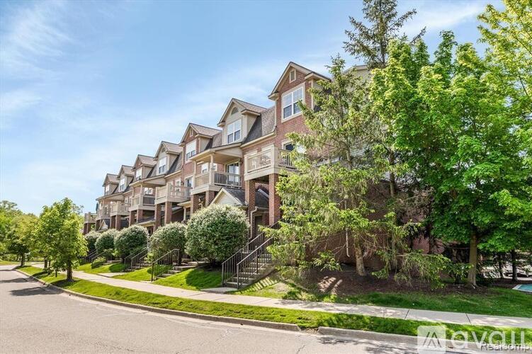 A row of townhouses with green trees in front.