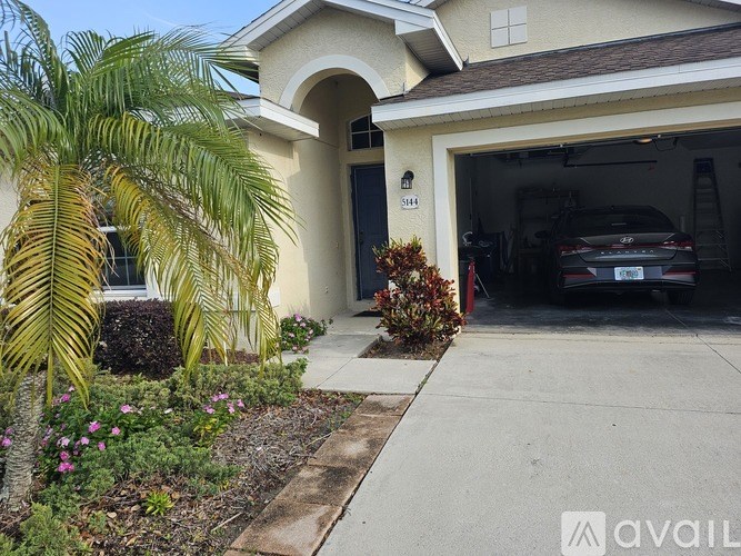 A house with a garage and a car inside it.