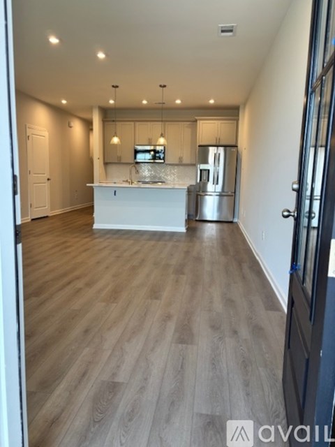 A kitchen with wooden floors and stainless steel appliances.