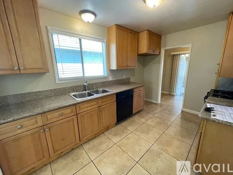 A kitchen with wooden cabinets and a granite countertop.