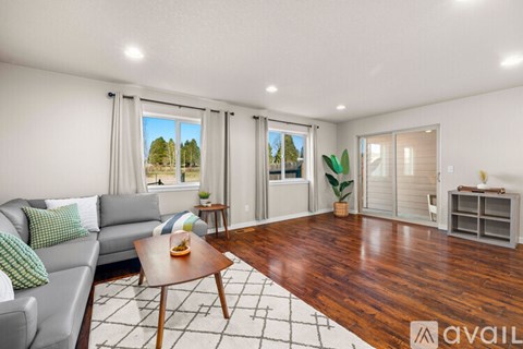 A living room with a grey couch and a wooden coffee table.