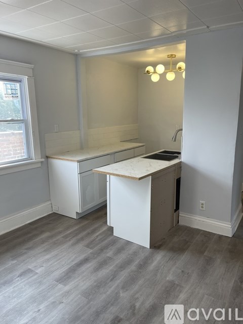 A kitchen with a white counter and a window.