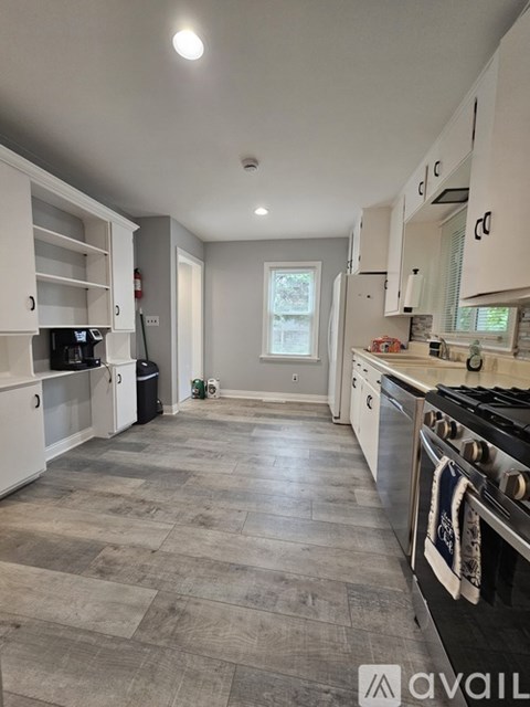A kitchen with a black stove top oven and white cabinets.