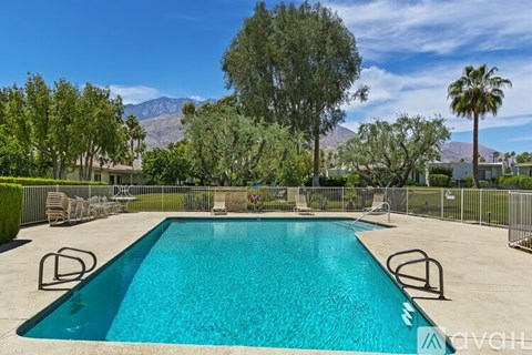 A swimming pool surrounded by a fence and trees.